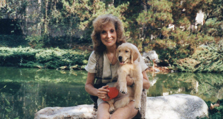 Marion hold her puppy, Holly, in her arms in the park.
