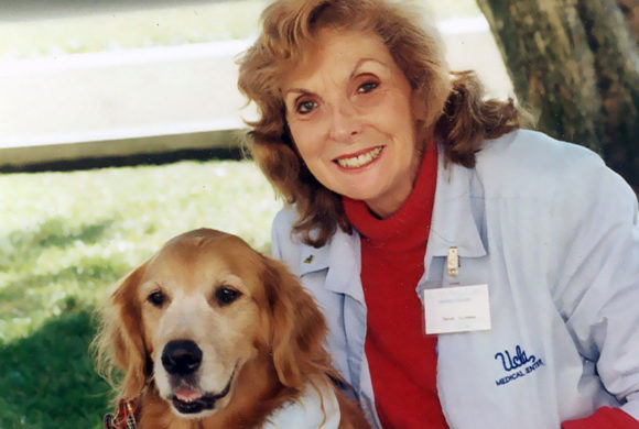 Marian Silverman posing with her dog Holly in the park.